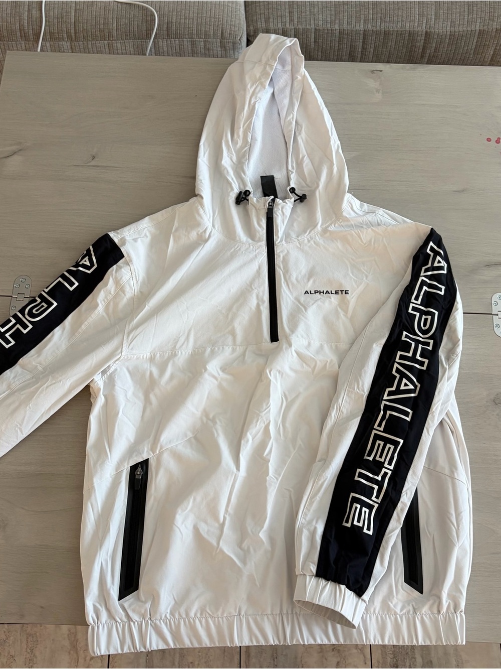 Alphalete White Hooded Windbreaker with Black Sleeve Branding